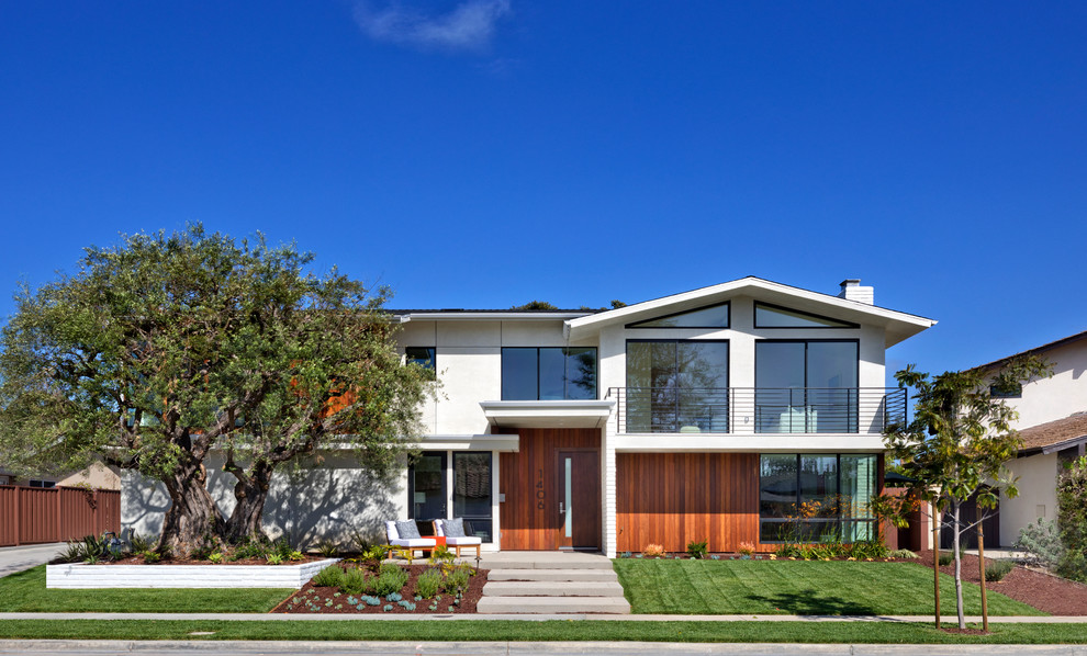 This is an example of a midcentury two-storey white house exterior in Orange County with mixed siding, a gable roof and a shingle roof.