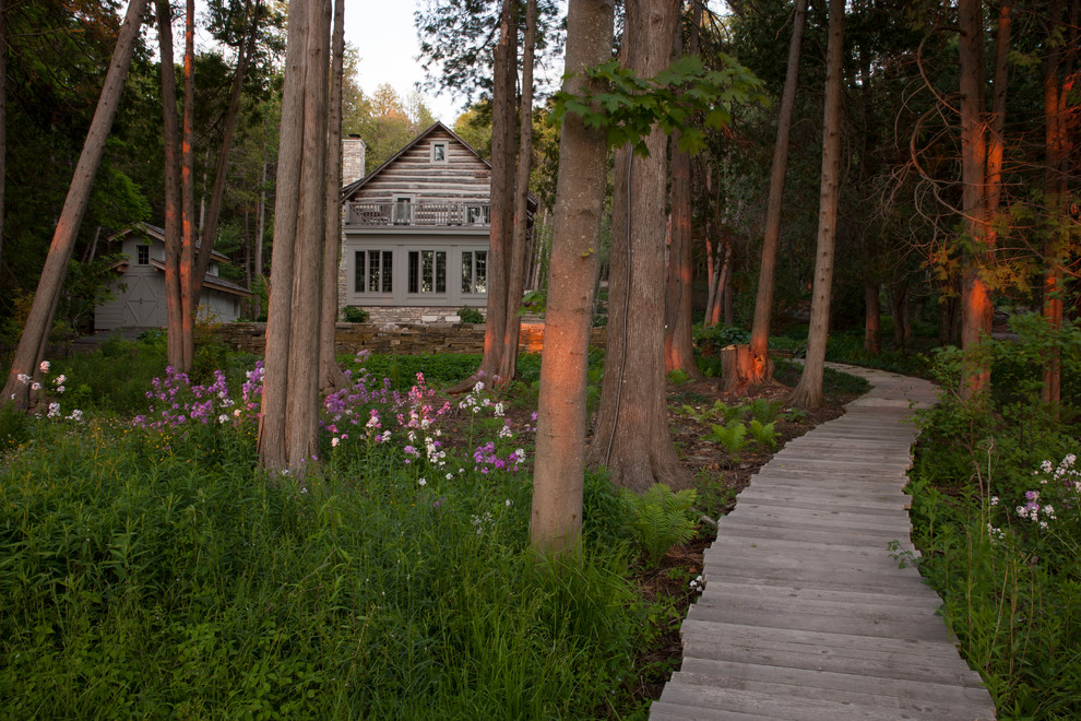 Photo of a large rustic partial sun backyard landscaping with decking for summer.