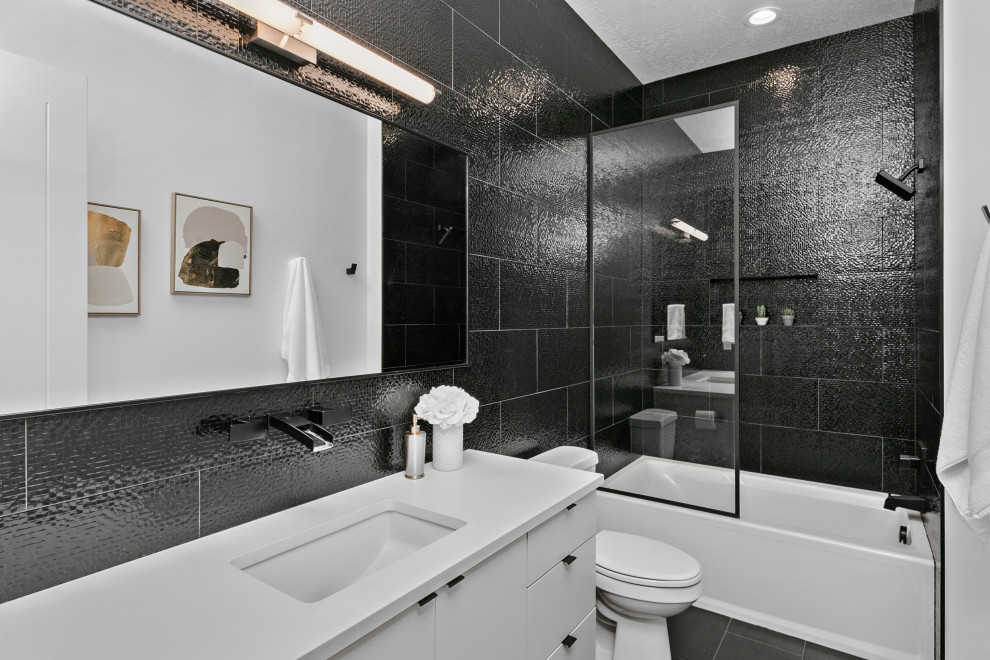 Réalisation d'une grande salle de bain minimaliste avec un placard à porte plane, des portes de placard blanches, une baignoire en alcôve, un combiné douche/baignoire, WC séparés, un carrelage noir, des carreaux de céramique, un mur noir, un sol en carrelage de céramique, un lavabo encastré, un plan de toilette en quartz modifié, un sol noir, une cabine de douche à porte coulissante, un plan de toilette blanc, meuble simple vasque et meuble-lavabo suspendu.
