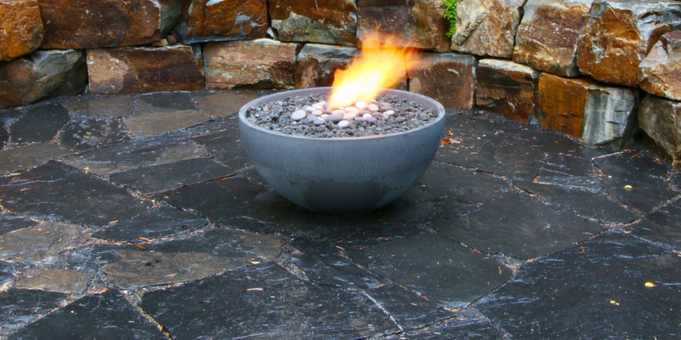 Inspiration for a small rustic stone patio remodel in Edmonton with a fire pit