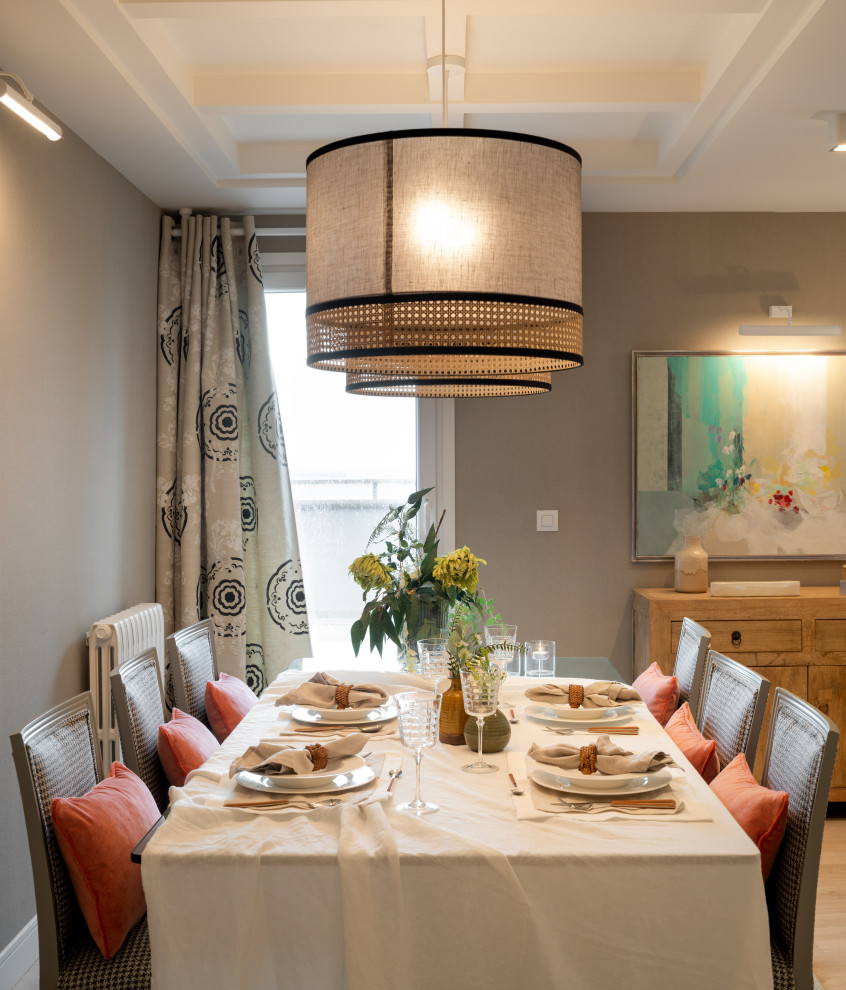 This is an example of a large transitional open plan dining in Bilbao with grey walls, laminate floors, a ribbon fireplace, brown floor, coffered and wallpaper.