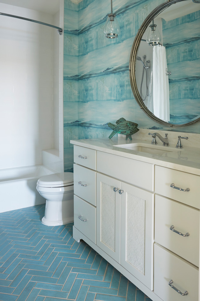 Inspiration for a mid-sized beach style kids bathroom in Jacksonville with recessed-panel cabinets, white cabinets, an alcove tub, an alcove shower, a two-piece toilet, white tile, porcelain tile, blue walls, porcelain floors, an undermount sink, marble benchtops, turquoise floor and a shower curtain.