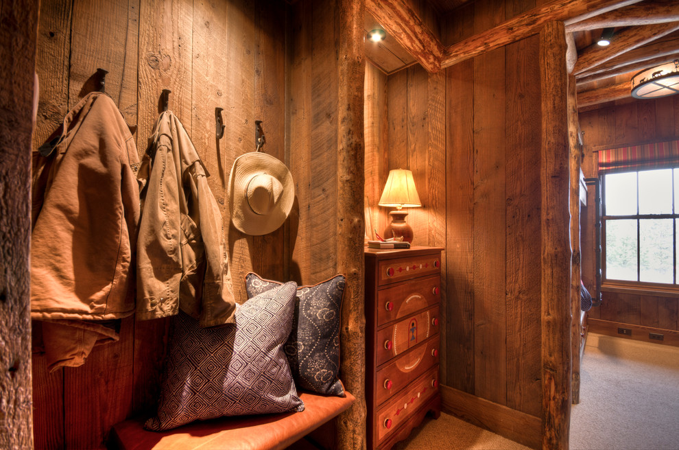 This is an example of a mid-sized traditional mudroom in Other with carpet and brown walls.