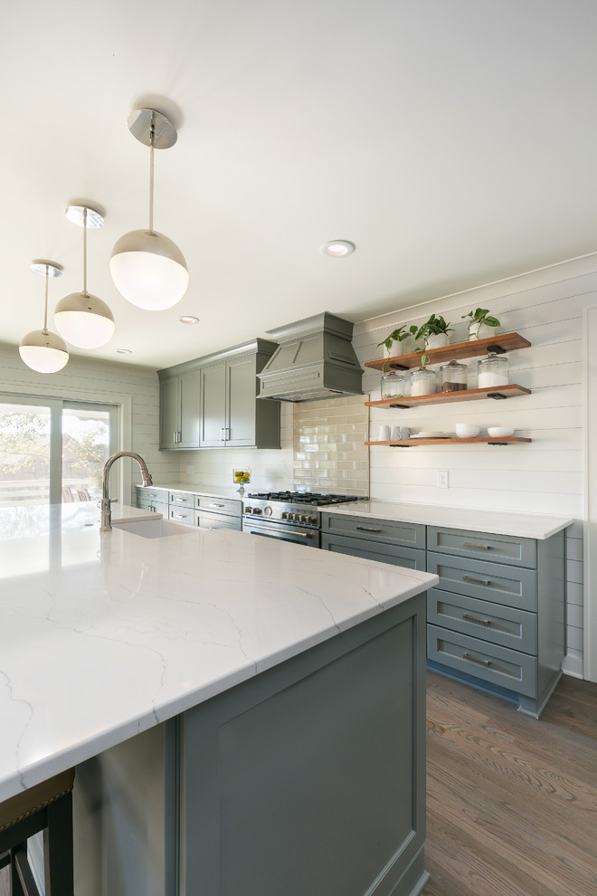 Design ideas for a mid-sized modern l-shaped open plan kitchen with a farmhouse sink, shaker cabinets, grey cabinets, beige splashback, subway tile splashback, stainless steel appliances, medium hardwood floors, with island, brown floor and white benchtop.