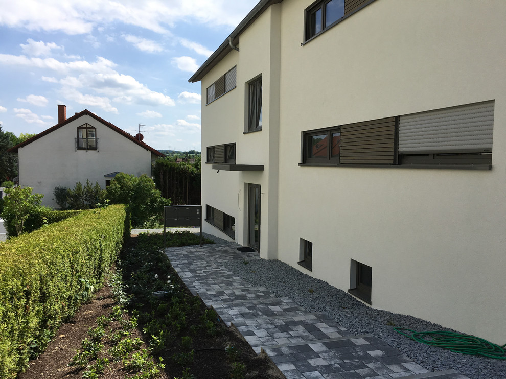 Großes, Zweistöckiges Modernes Einfamilienhaus mit Putzfassade, weißer Fassadenfarbe, Halbwalmdach und Ziegeldach in München