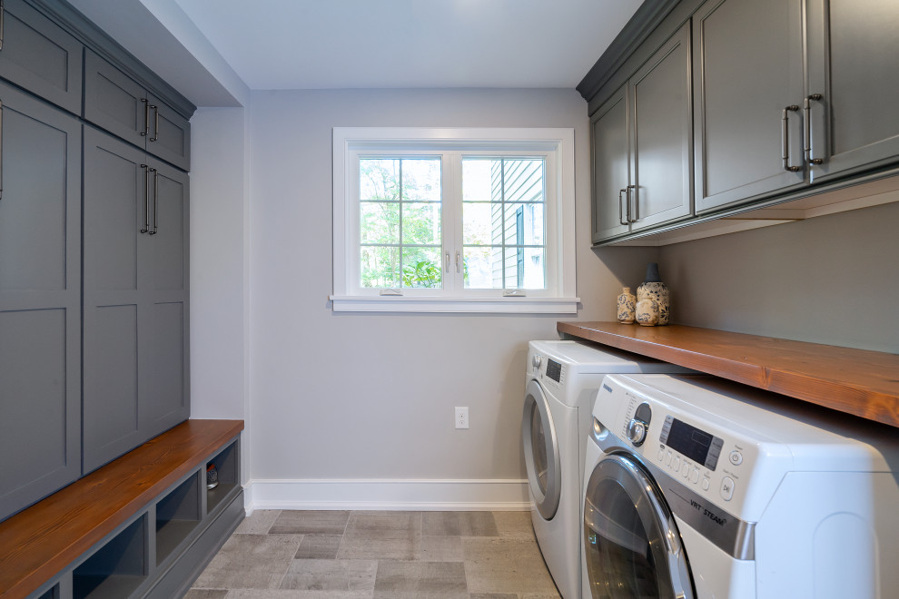 Photo of a mid-sized country laundry room in Philadelphia with grey walls and porcelain floors.