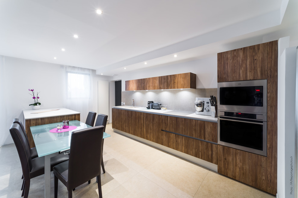 Photo of a large contemporary single-wall open plan kitchen in Nice with a double-bowl sink, flat-panel cabinets, dark wood cabinets, laminate benchtops, grey splashback, ceramic splashback, stainless steel appliances, ceramic floors, with island and beige floor.