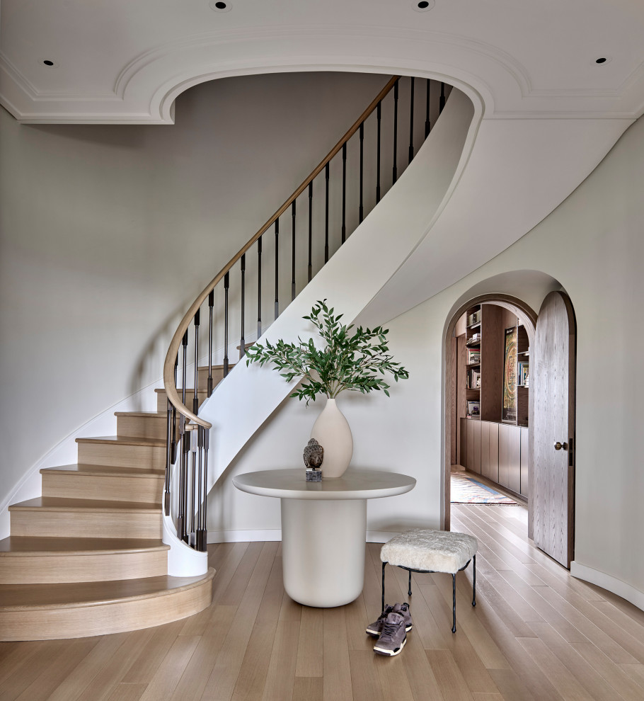 Staircase - large contemporary wooden curved metal railing staircase idea in Chicago with wooden risers