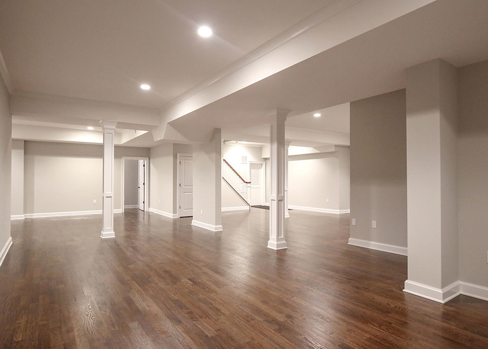 This is an example of a large transitional open concept family room in New York with grey walls, medium hardwood floors, no fireplace and no tv.