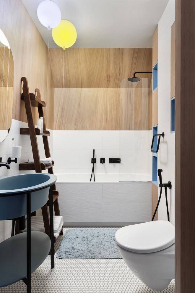 Свежая идея для дизайна: большая детская ванная комната в белых тонах с отделкой деревом: освещение в современном стиле с плоскими фасадами, светлыми деревянными фасадами, душем над ванной, инсталляцией, белой плиткой, плиткой, белыми стенами, полом из мозаичной плитки, консольной раковиной, белым полом, тумбой под одну раковину и ванной в нише - отличное фото интерьера