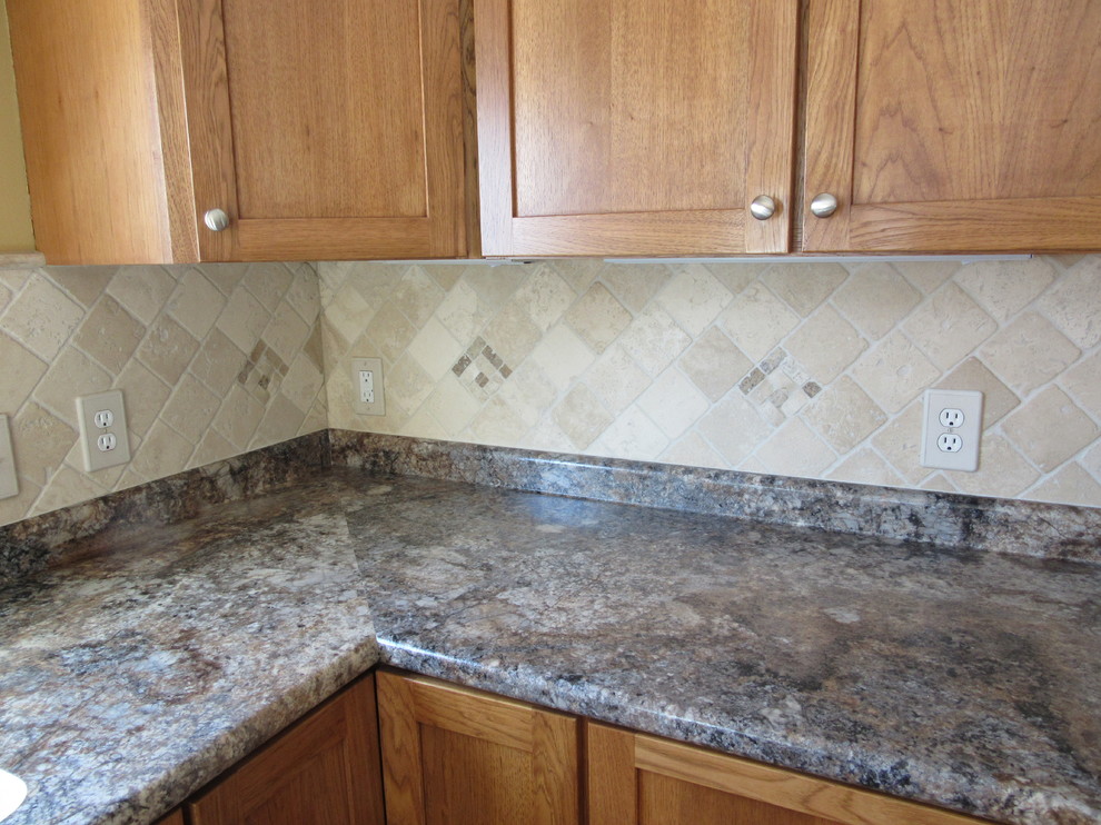 Example of a transitional u-shaped ceramic tile eat-in kitchen design with an integrated sink, shaker cabinets, medium tone wood cabinets, laminate countertops, beige backsplash, stone tile backsplash, stainless steel appliances and a peninsula
