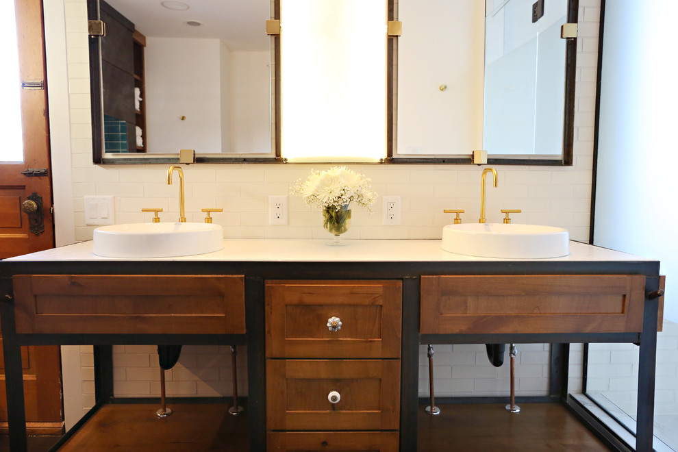 Photo of a large industrial master bathroom in Minneapolis with a drop-in sink, recessed-panel cabinets, medium wood cabinets, concrete benchtops, a freestanding tub, an alcove shower, a one-piece toilet, white tile, porcelain tile, white walls and cork floors.