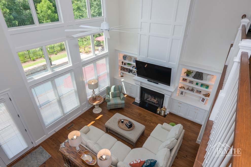 Inspiration pour une grande salle de séjour craftsman ouverte avec un mur blanc, parquet foncé, une cheminée standard, un manteau de cheminée en carrelage, un téléviseur fixé au mur et un sol marron.