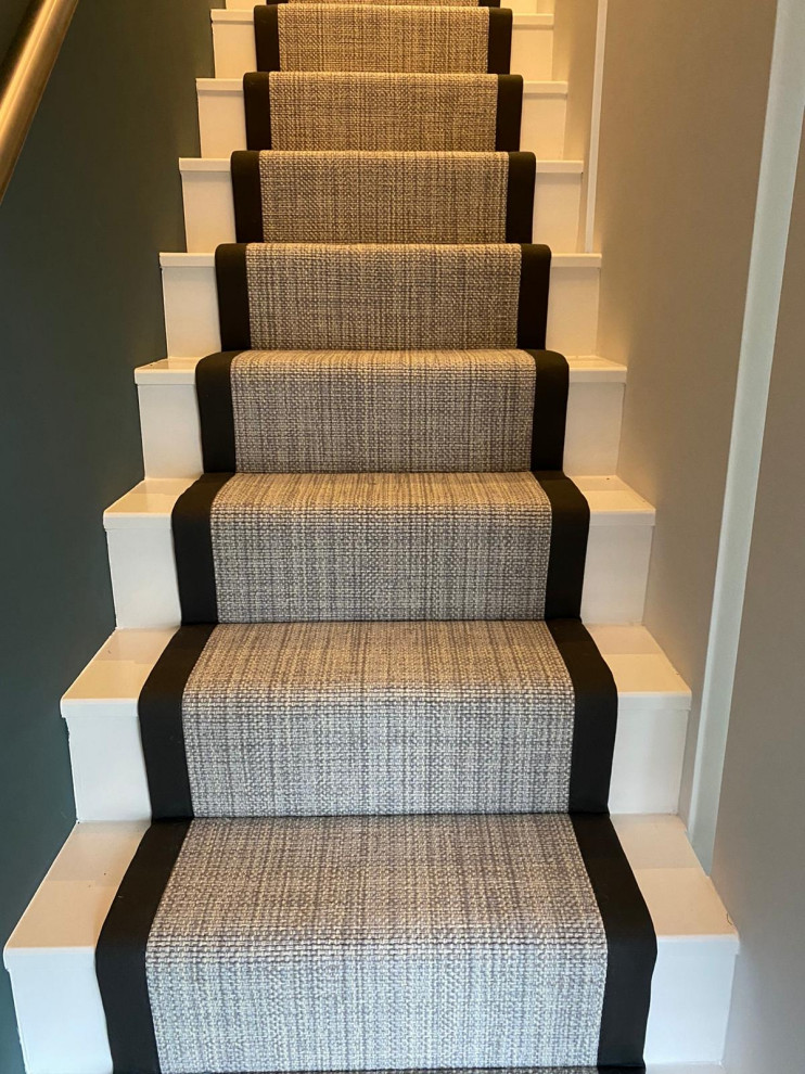 Inspiration for a large modern carpeted straight staircase in Hertfordshire with carpet risers and wood railing.