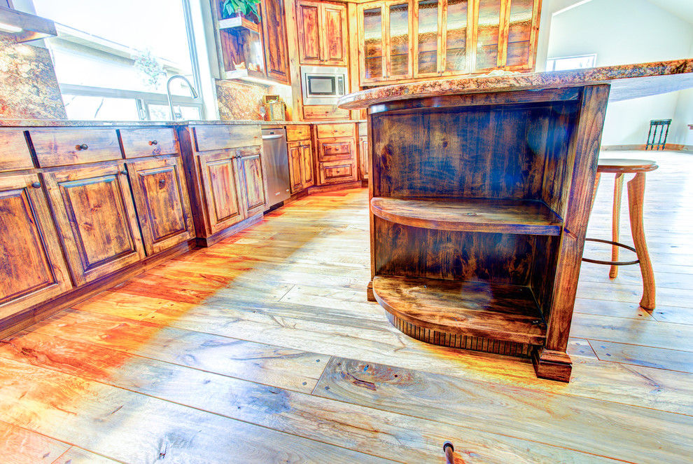 Kitchen pantry - large rustic u-shaped medium tone wood floor kitchen pantry idea with a drop-in sink, glass-front cabinets, medium tone wood cabinets, beige backsplash, stainless steel appliances and an island