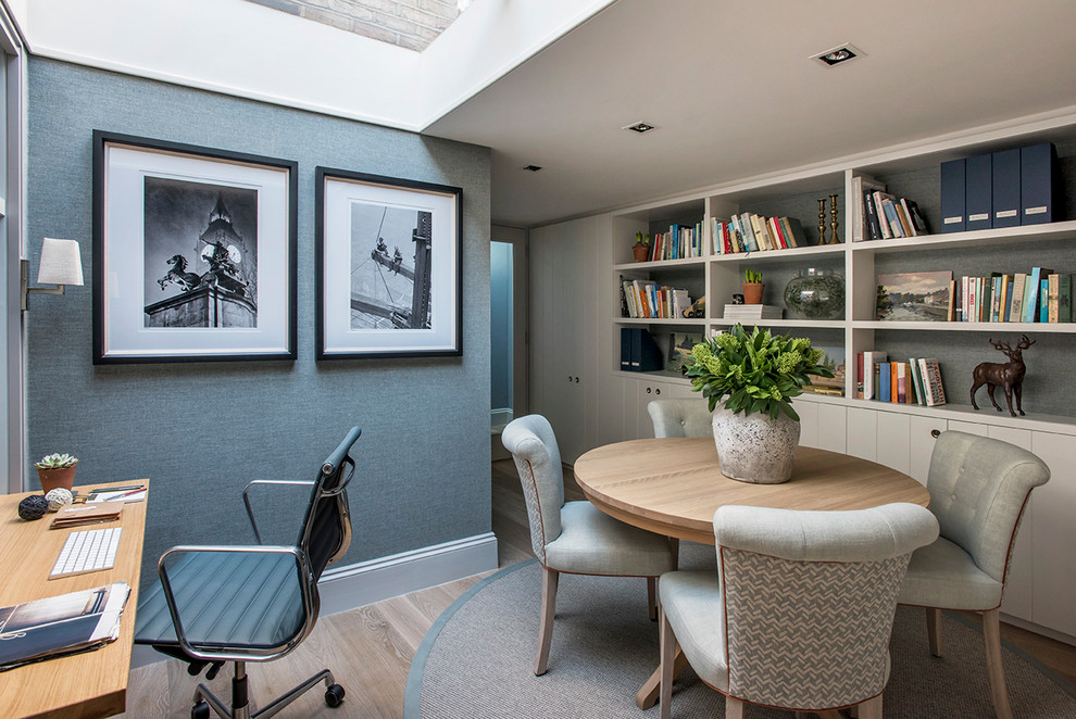 Photo of a transitional study room with grey walls, medium hardwood floors and brown floor.