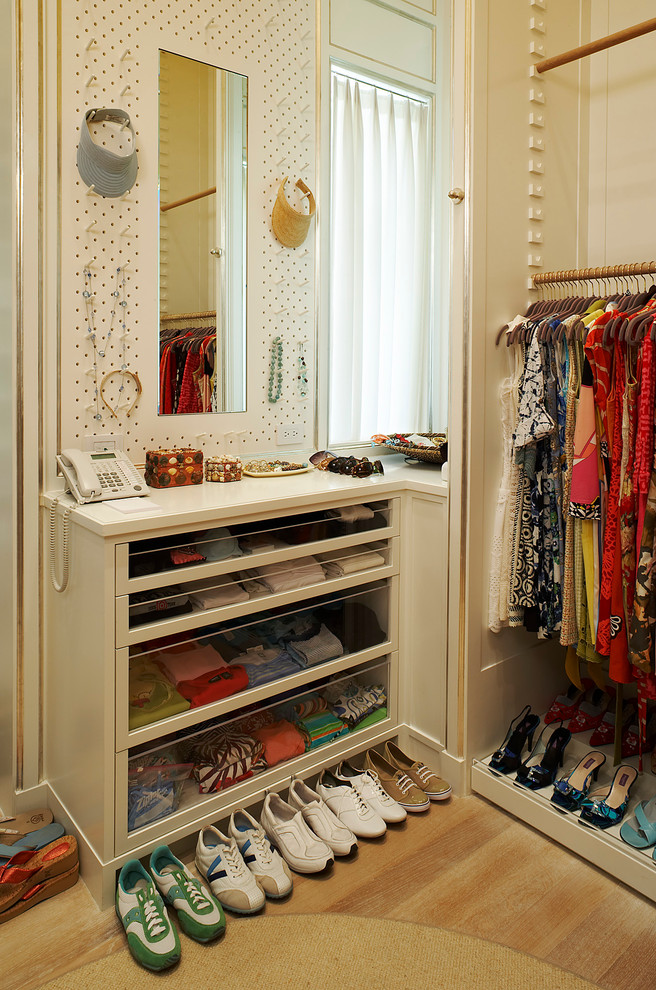 Photo of a transitional built-in wardrobe in New York with open cabinets and white cabinets.