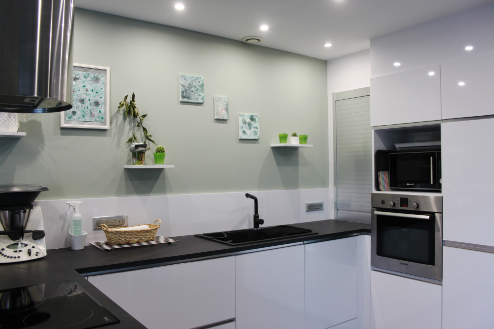 Esempio di una cucina contemporanea di medie dimensioni con lavello da incasso, ante bianche, top in laminato, paraspruzzi bianco, elettrodomestici in acciaio inossidabile, pavimento con piastrelle in ceramica, top nero e pavimento grigio