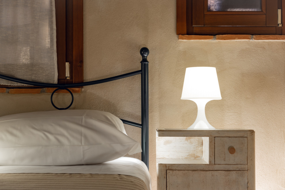 Foto de dormitorio principal rural pequeño con paredes beige, suelo de baldosas de porcelana, suelo gris y vigas vistas