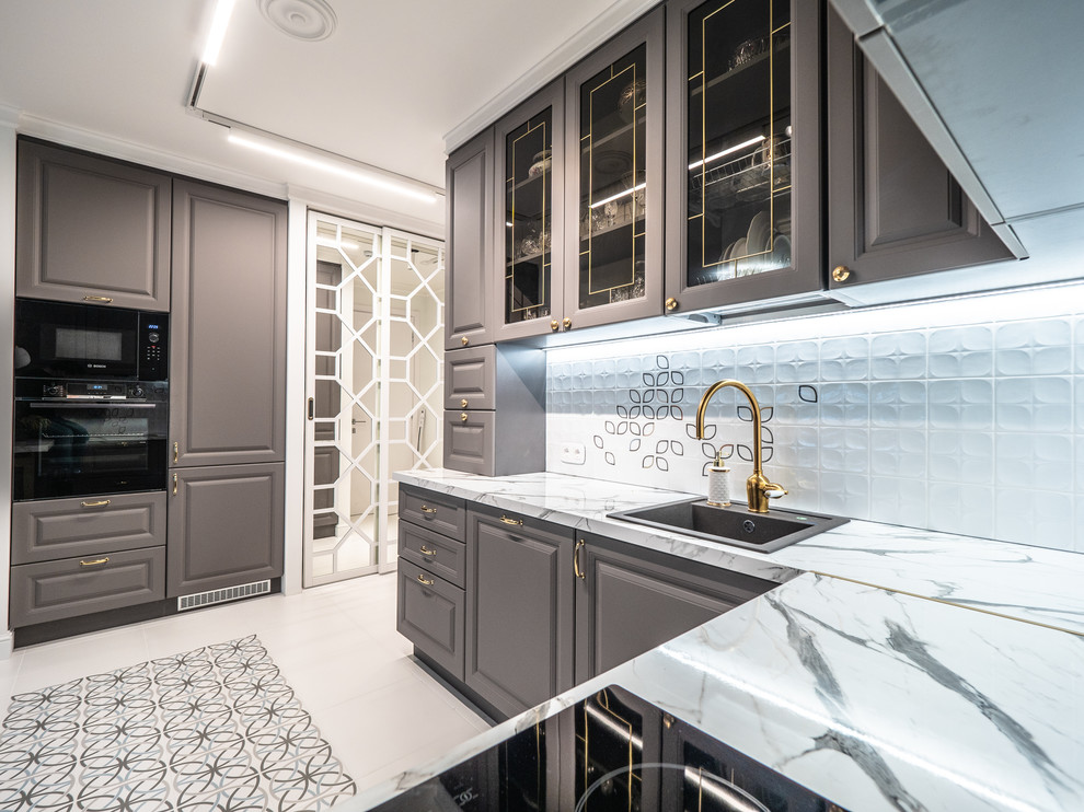 Photo of a small transitional u-shaped open plan kitchen in Saint Petersburg with an undermount sink, recessed-panel cabinets, grey cabinets, marble benchtops, white splashback, ceramic splashback, panelled appliances, porcelain floors, a peninsula, white floor and white benchtop.