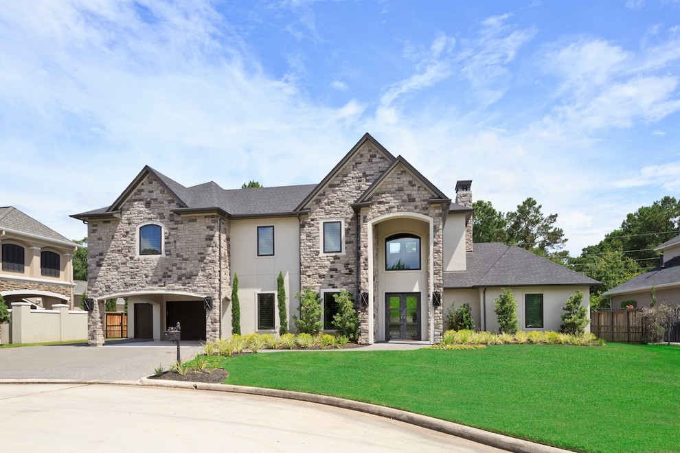 Example of a large transitional beige two-story stone exterior home design in Houston