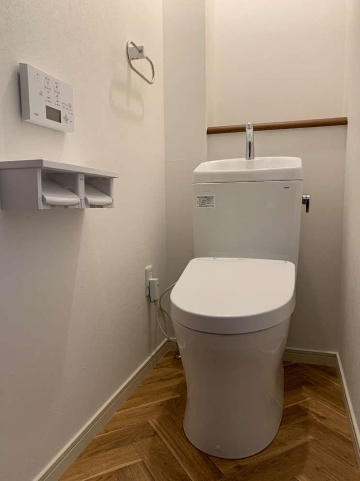 Стильный дизайн: туалет в современном стиле с белыми стенами, коричневым полом, потолком с обоями и обоями на стенах - последний тренд