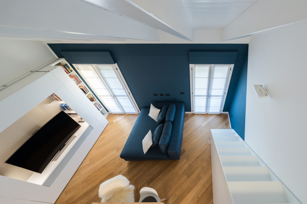 Kleines, Offenes Skandinavisches Wohnzimmer mit bunten Wänden, hellem Holzboden, Multimediawand, beigem Boden und Holzdecke in Mailand