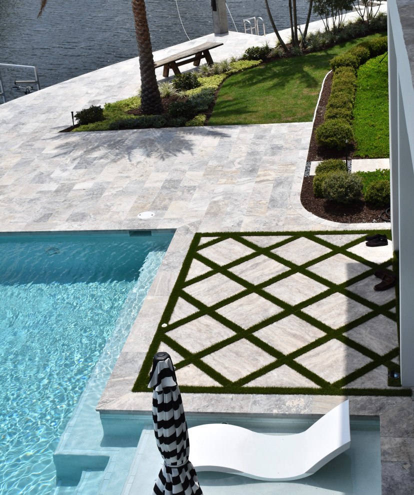 Photo of an expansive beach style back formal full sun garden in Miami with a garden path and natural stone paving.