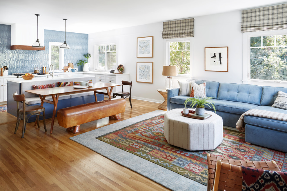This is an example of a transitional open concept living room in Los Angeles with white walls, medium hardwood floors and brown floor.