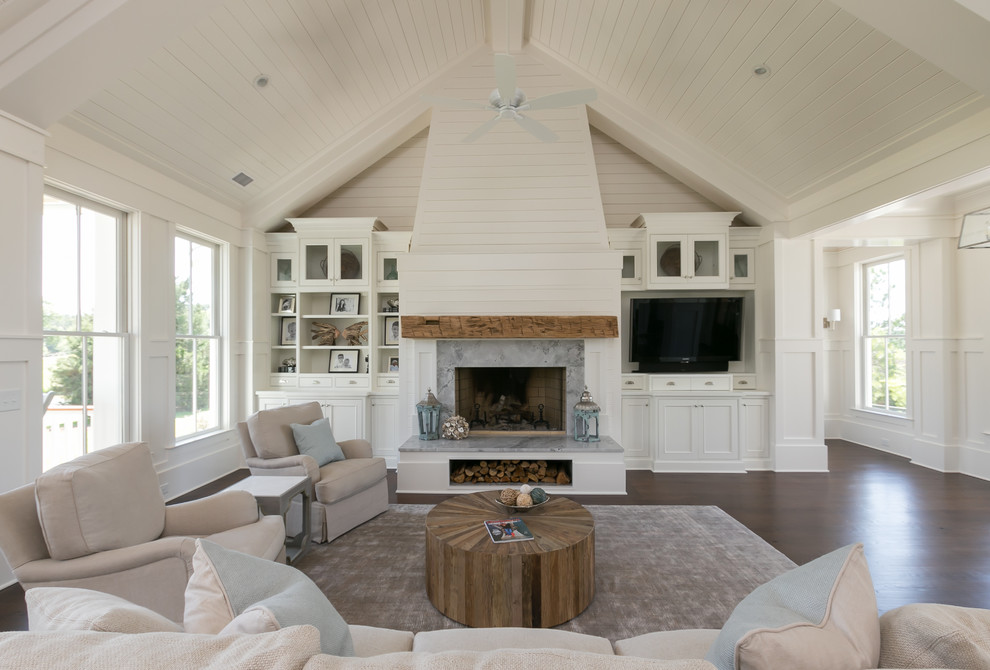 Inspiration for a beach style family room in Charleston with white walls, dark hardwood floors, a standard fireplace and a built-in media wall.