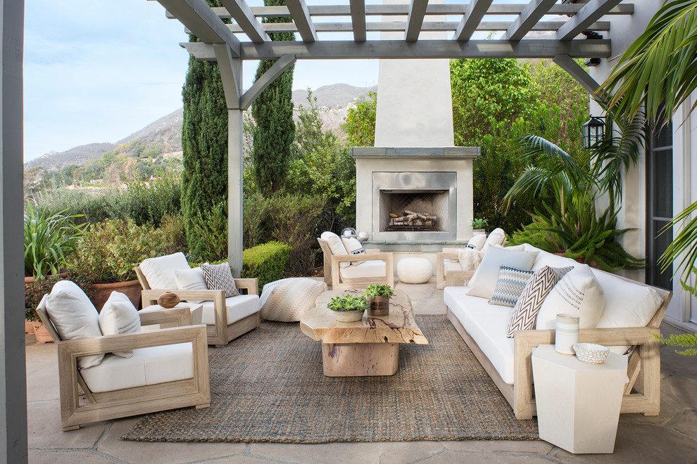 Design ideas for a mid-sized beach style backyard patio in Santa Barbara with a pergola, natural stone pavers and with fireplace.