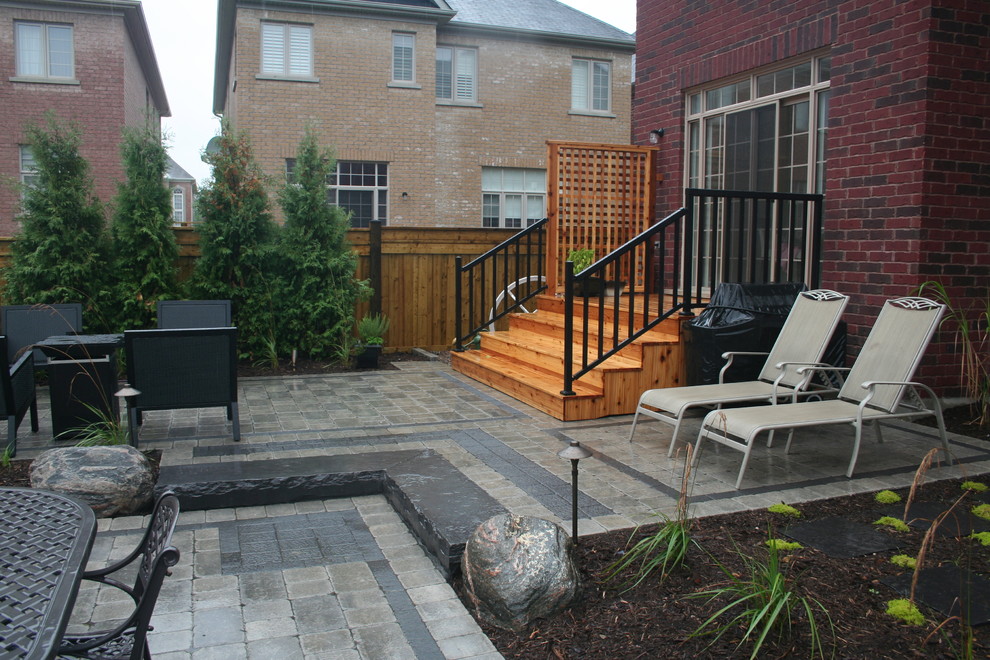 Small modern backyard full sun formal garden in Toronto with concrete pavers for summer.