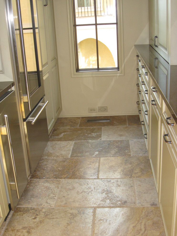Example of a transitional galley travertine floor and beige floor kitchen design with raised-panel cabinets, beige cabinets, stainless steel appliances and no island