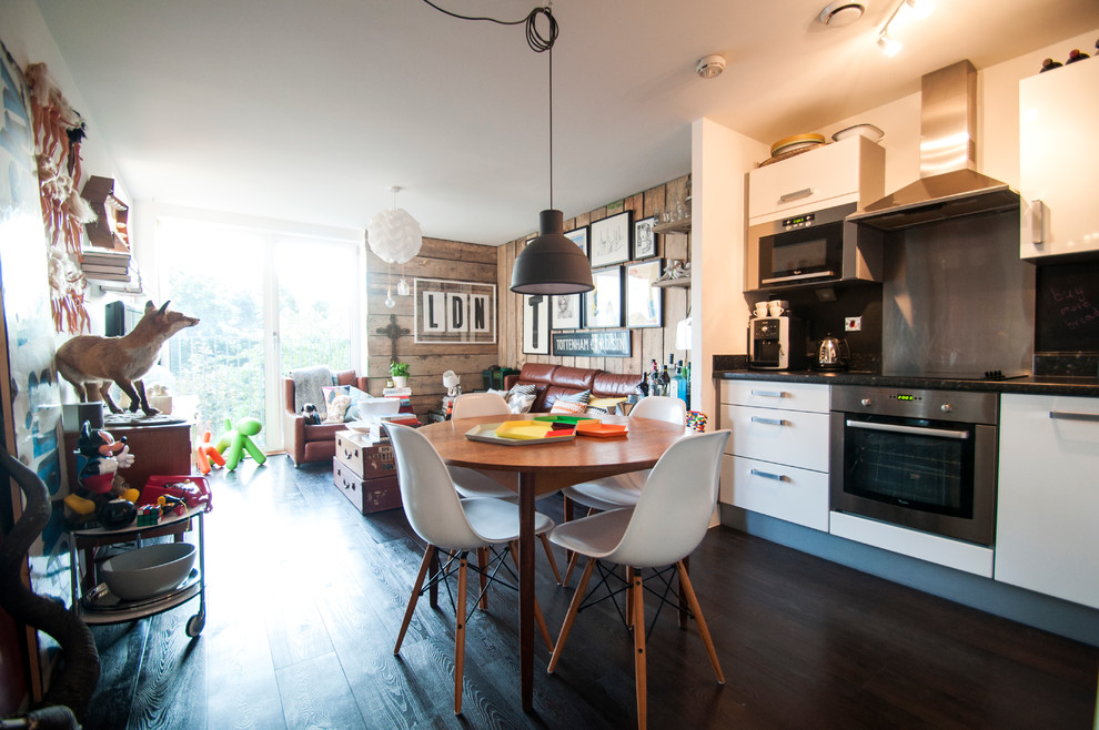 This is an example of a mid-sized eclectic l-shaped eat-in kitchen in London with a double-bowl sink, white cabinets and no island.