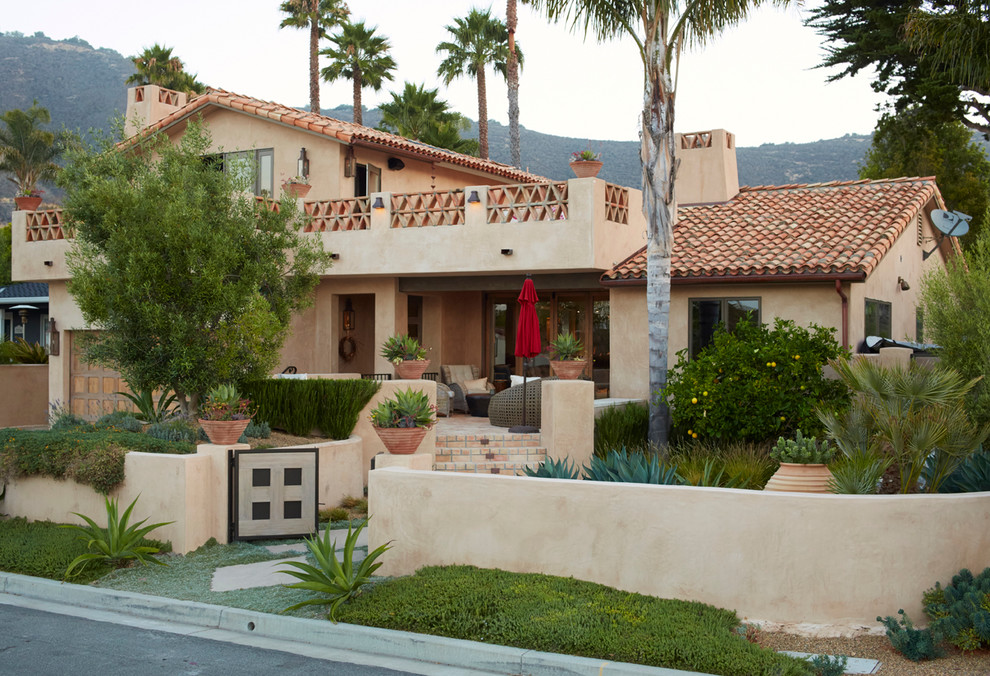 This is an example of a mid-sized mediterranean two-storey concrete beige exterior in San Luis Obispo with a gable roof.