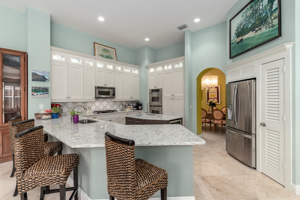 Transitional kitchen pantry photo with an undermount sink, quartz countertops, porcelain backsplash, stainless steel appliances and an island