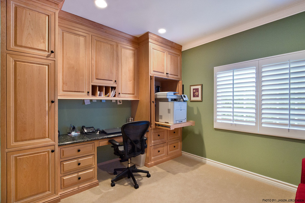 Photo of a mid-sized traditional home office in Los Angeles with green walls, carpet and a built-in desk.