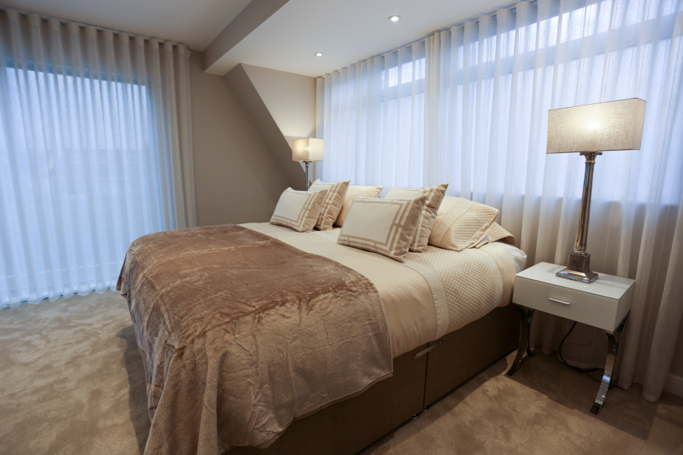 Photo of a large contemporary master bedroom in Hertfordshire with beige walls, carpet and beige floor.