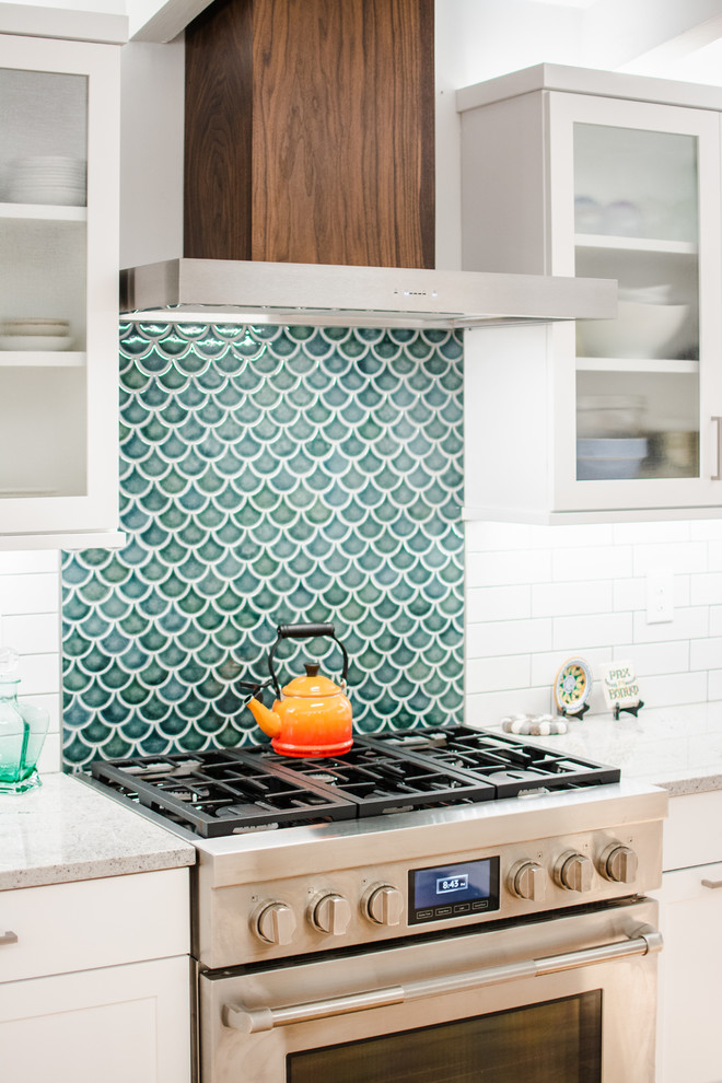Inspiration for a large midcentury l-shaped eat-in kitchen in Denver with an undermount sink, shaker cabinets, white cabinets, granite benchtops, green splashback, mosaic tile splashback, panelled appliances, light hardwood floors, with island and grey benchtop.