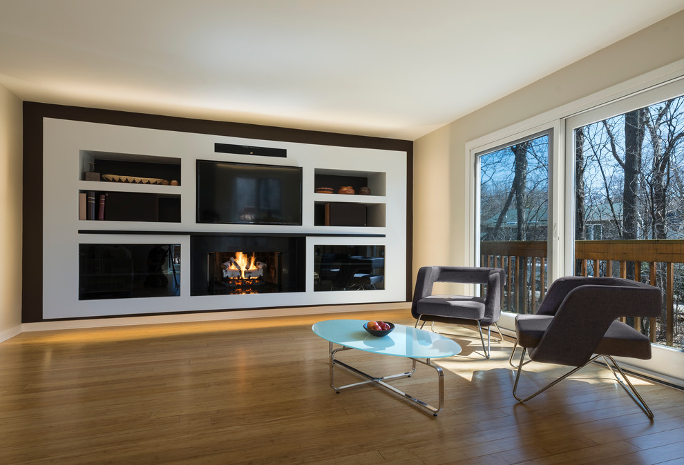 Photo of a large modern formal enclosed living room in Chicago with beige walls, light hardwood floors, a standard fireplace, a built-in media wall, a metal fireplace surround and brown floor.