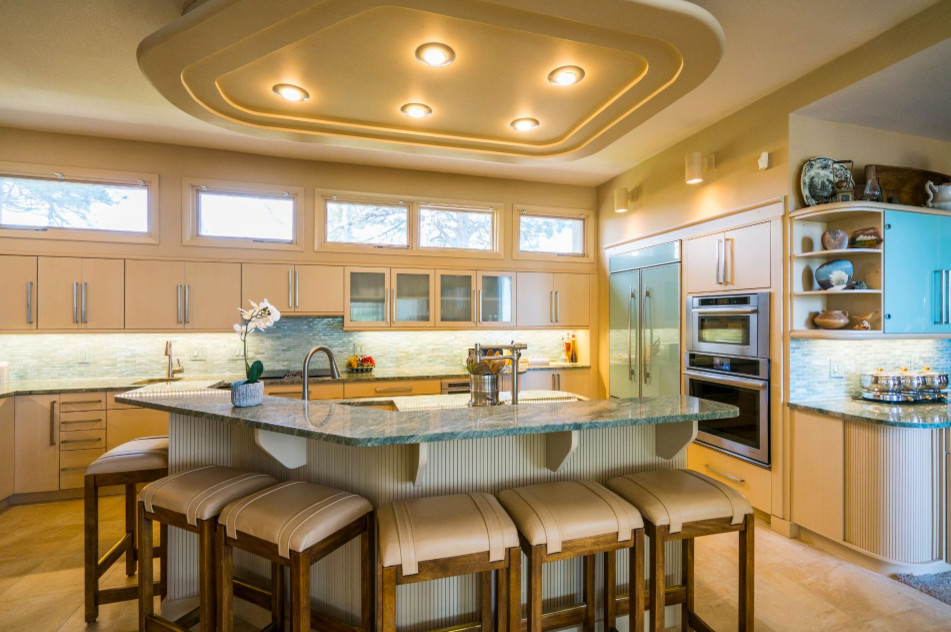 This is an example of a large midcentury u-shaped open plan kitchen in Denver with a double-bowl sink, flat-panel cabinets, light wood cabinets, granite benchtops, green splashback, matchstick tile splashback, stainless steel appliances, ceramic floors, with island and beige floor.