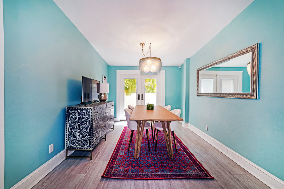 Ispirazione per una piccola sala da pranzo aperta verso la cucina classica con pareti blu, pavimento in gres porcellanato e pavimento marrone