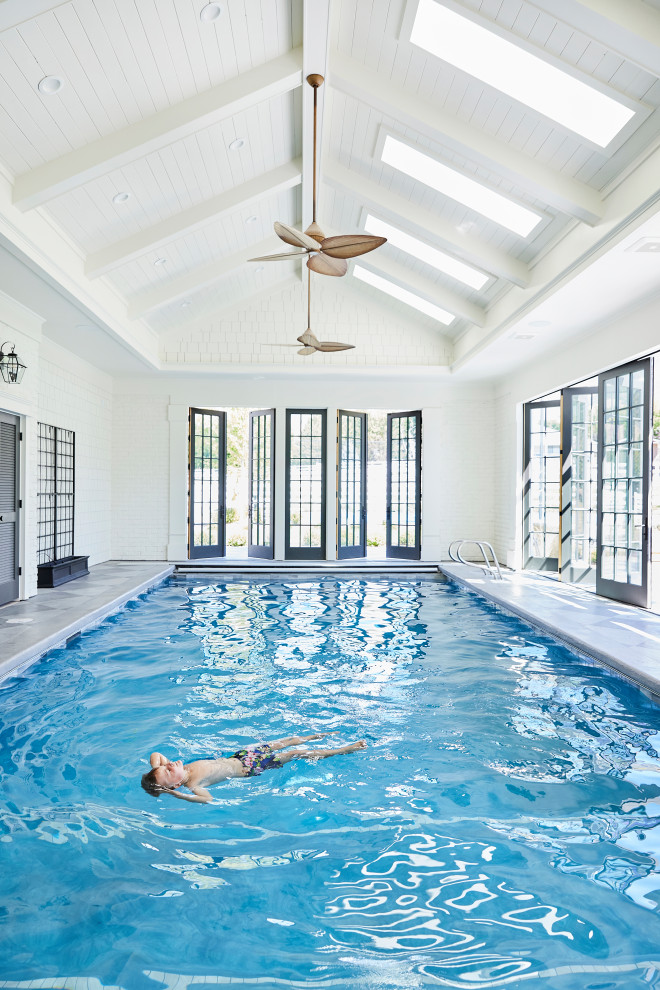 Foto de piscina clásica grande interior y rectangular con losas de hormigón