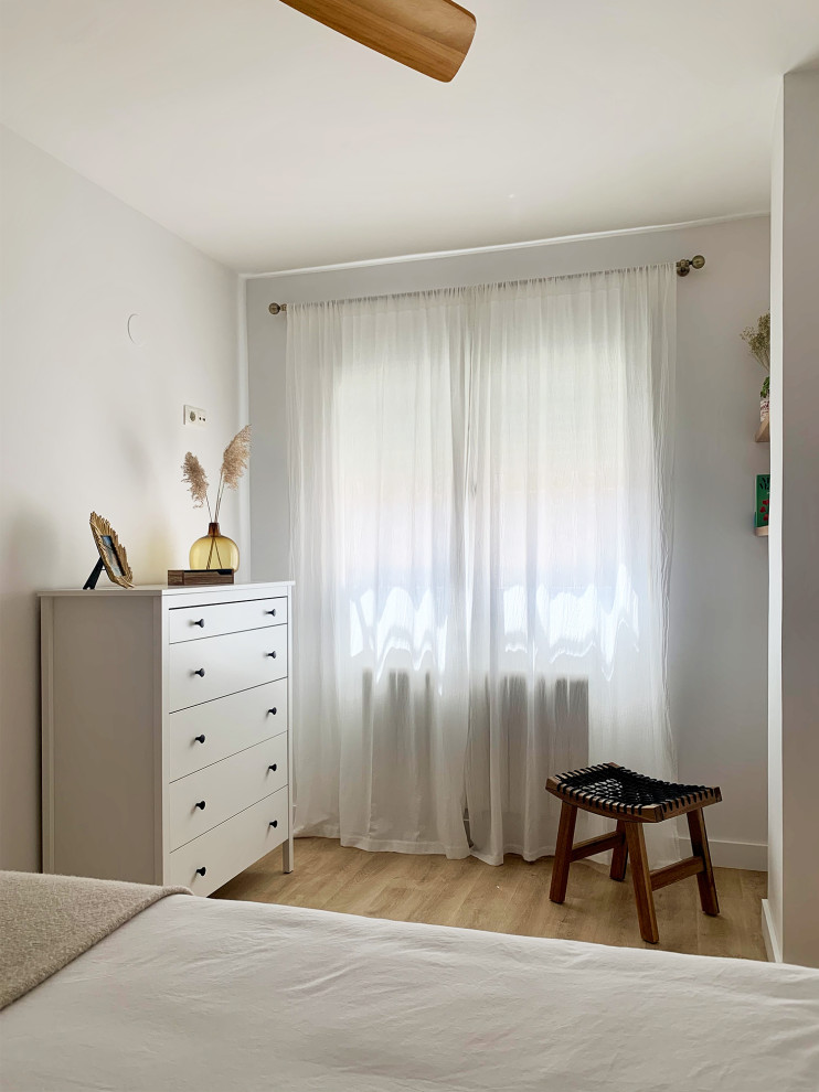 Modelo de dormitorio principal y blanco y madera nórdico de tamaño medio con paredes blancas, suelo de madera en tonos medios y suelo beige