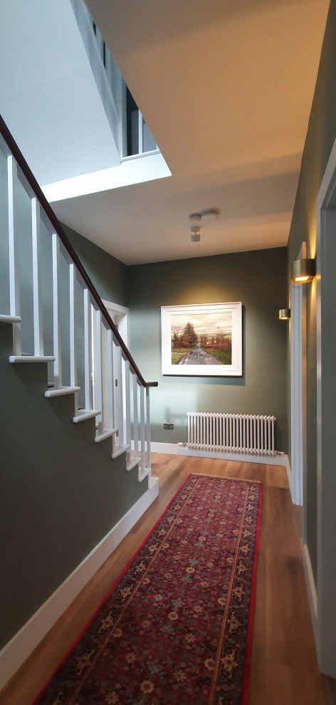 Ispirazione per un ingresso o corridoio classico con pareti verdi, pavimento in legno massello medio e pavimento marrone