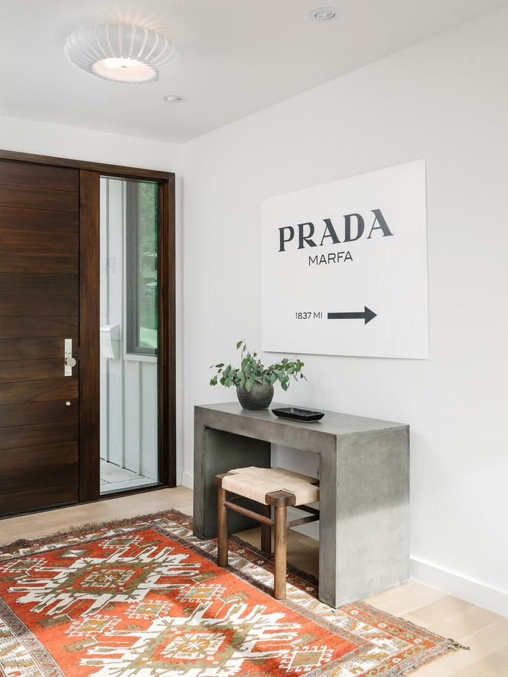 Trendy light wood floor and beige floor entryway photo in Austin with white walls and a dark wood front door