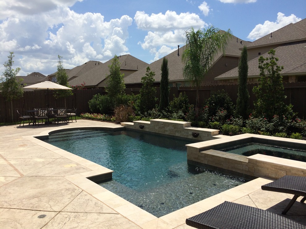 Photo of a large contemporary backyard rectangular pool in Houston with a hot tub and stamped concrete.