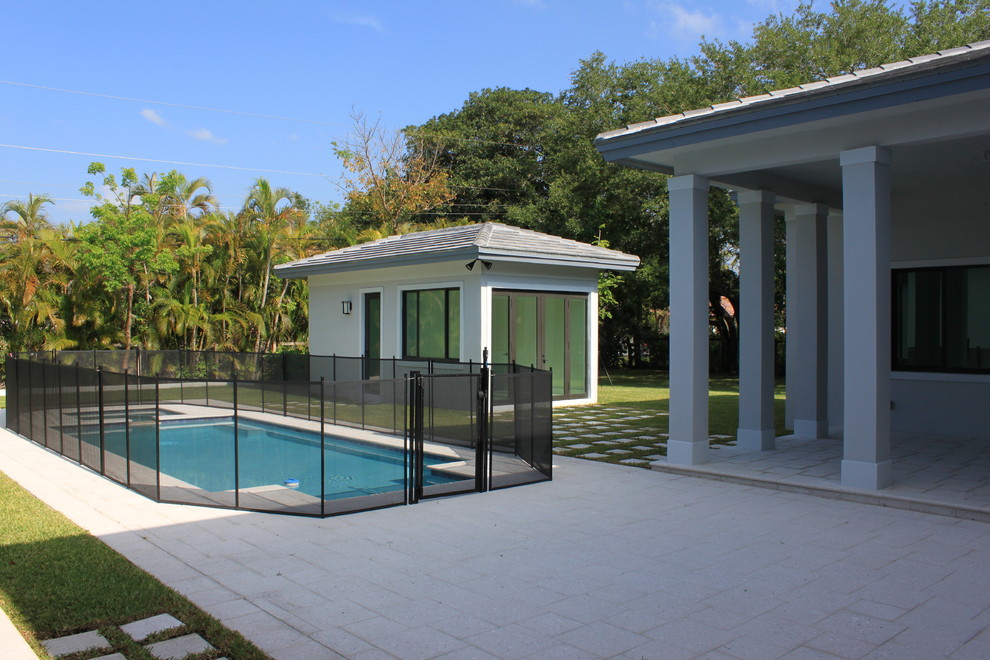 Inspiration for a mid-sized transitional backyard rectangular natural pool in Miami with a pool house and tile.