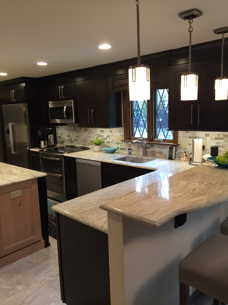 Example of a transitional ceramic tile kitchen design with a single-bowl sink, dark wood cabinets, multicolored backsplash, mosaic tile backsplash, stainless steel appliances and an island
