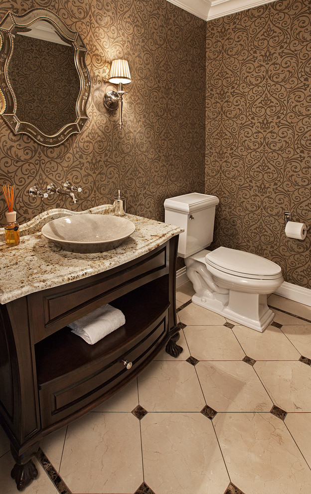 Photo of a small traditional powder room in Chicago with a vessel sink, raised-panel cabinets, a two-piece toilet, beige tile, brown walls, marble floors and dark wood cabinets.